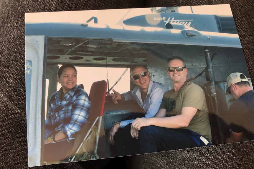 A photo of three people in a helicopter.