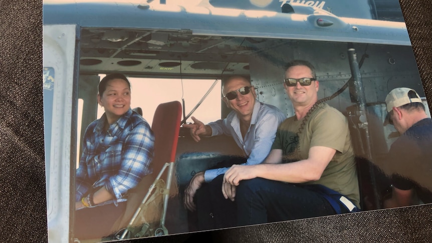 A photo of three people in a helicopter.