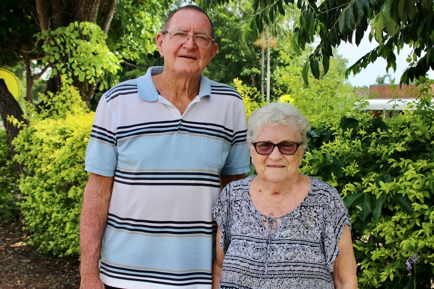 A man and a woman stand in front of greenery in Howard Springs in the NT. 