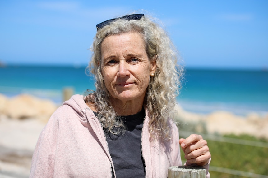 Jane Atkinson looking at the camera with ocean in the background.