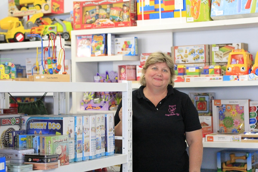 Woman smiling in a shop full of children's toys