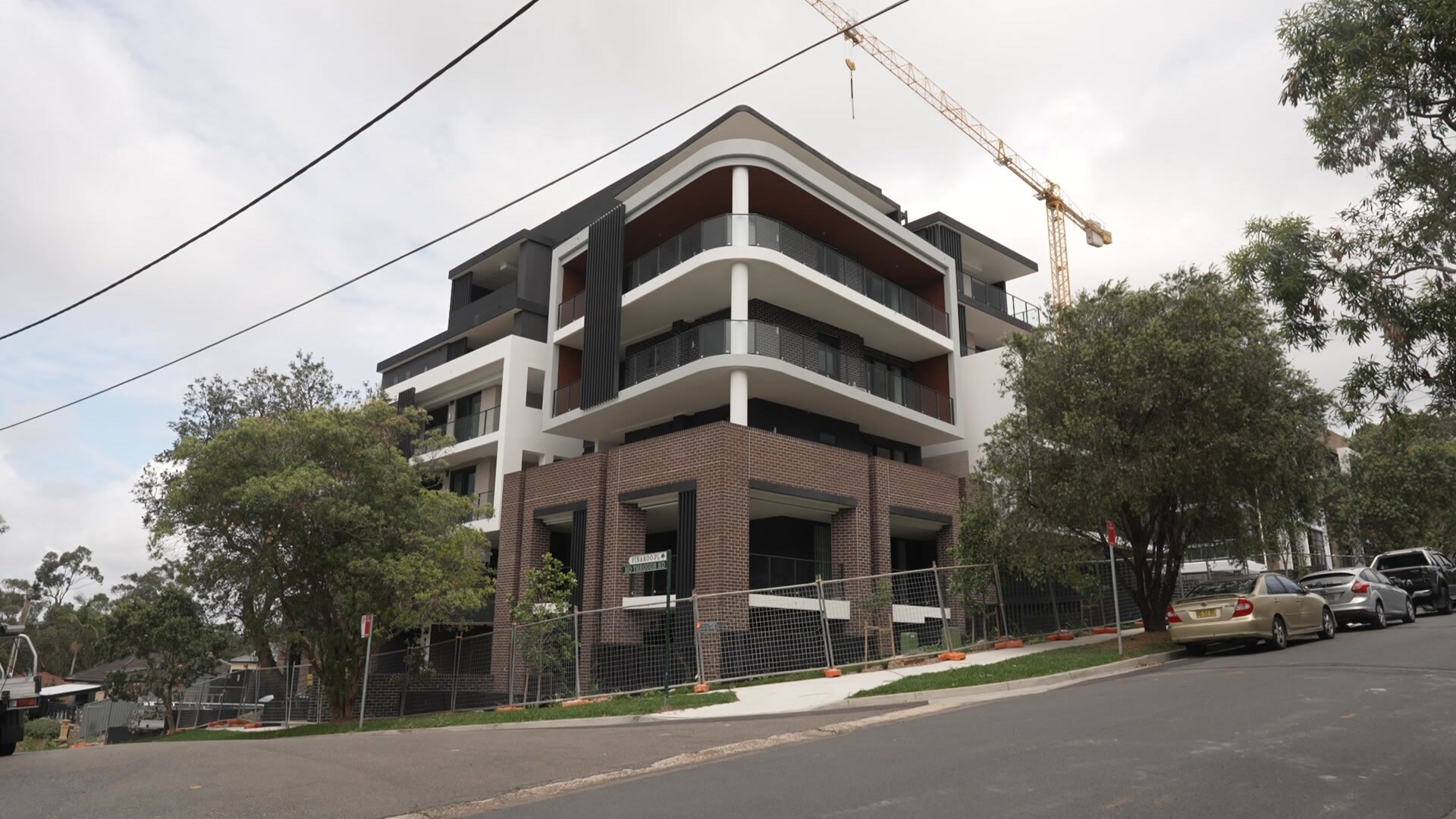 Un bloque de apartamentos en la esquina de una calle en construcción. 