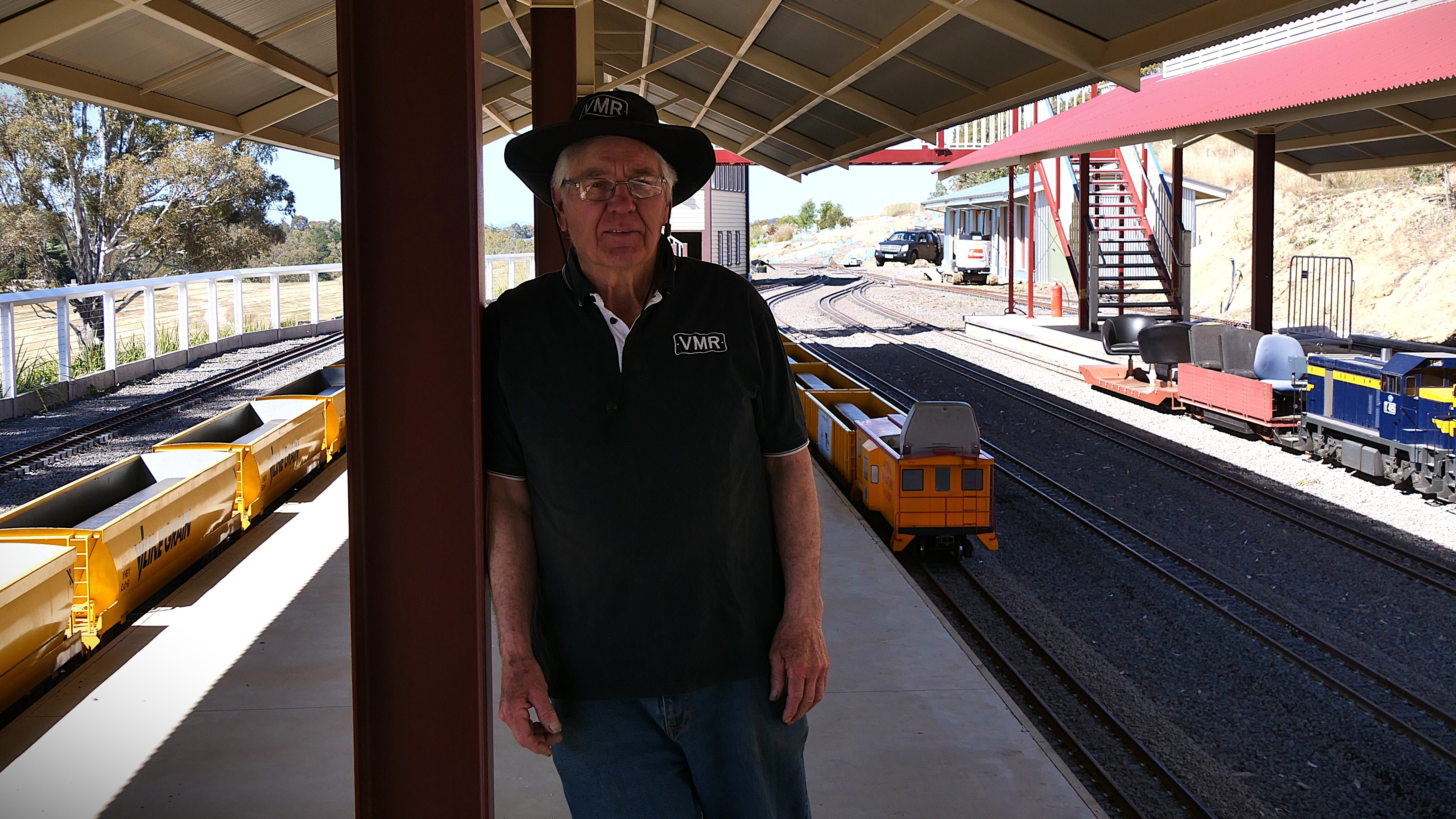 Un hombre se apoya contra un pilar en el andén de un tren.