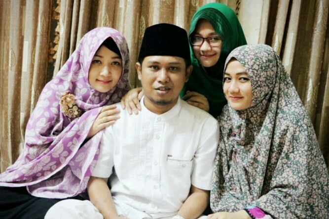 One of Indonesia's most well-known polygamists, Fadil Muzakki Syah, surrounded by his three wives.