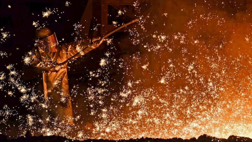 A steel-worker is pictured at a furnace at the plant of German steel company Salzgitter AG