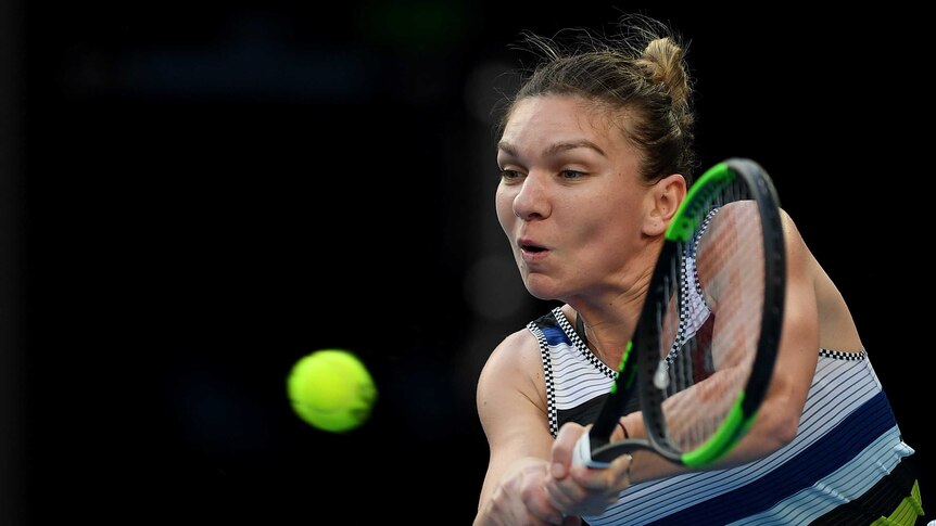 Simona Halep plays a double handed backhand with the ball in front of her.