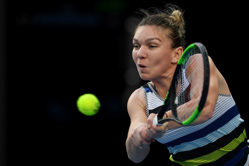 Simona Halep plays a double handed backhand with the ball in front of her.