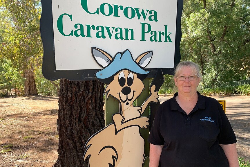Karen Dunstan stans in from of a Corowa Caravan Park sign