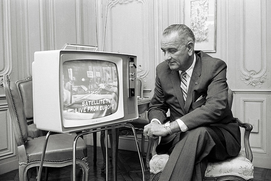 Lyndon Johnson watches television in a living room