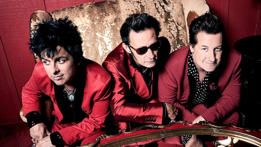 The three members of Green Day in dark red suits