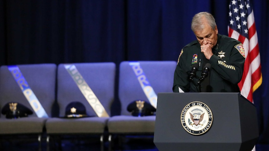 Sheriff Sid Gautreaux holds his hand to his mouth during his speech at a memorial for police officers killed in Baton Rouge.