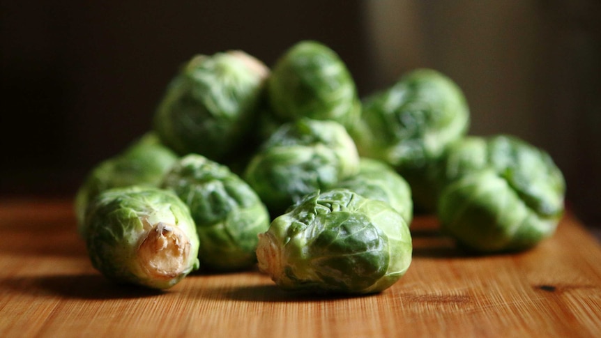 Brussels sprouts, stacked on a wooden board