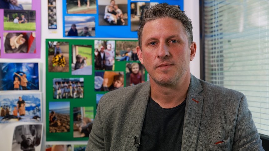 Mark McCudden sitting in his office in front of pictures of his family.