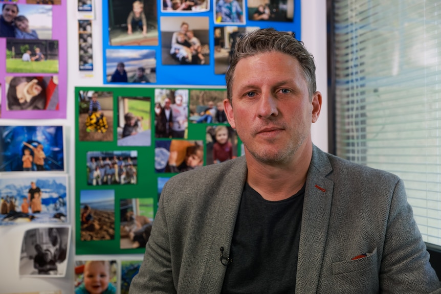 Mark McCudden sitting in his office in front of pictures of his family.