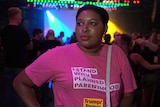 A woman looking proud while wearing a t-shirt which reads "I stand with Planned Parenthood"
