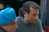 Captain Francesco Schettino is escorted into a prison by police officers at Grosseto.