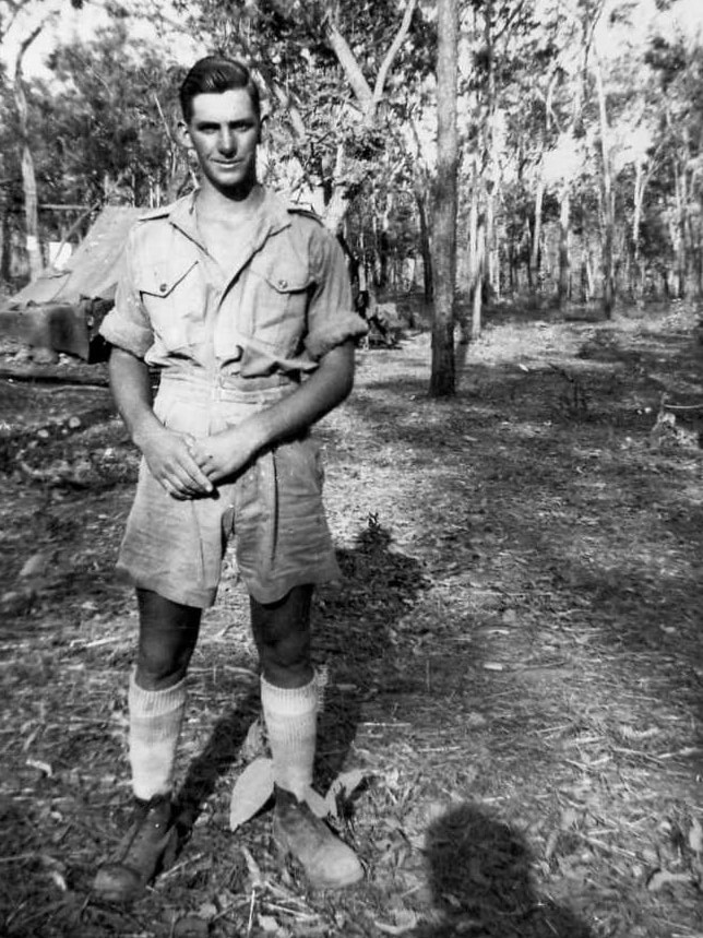 Mervyn Lloyd Ey as a young soldier stands in uniform in the Top End bush