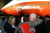 Mr Sutter hugs another person in front of a red and white Boeing. 