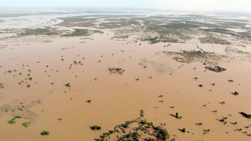 An outcrop of buildings sit among floodwaters spreading for hundreds of kilometres