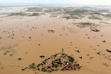 An outcrop of buildings sit among floodwaters spreading for hundreds of kilometres