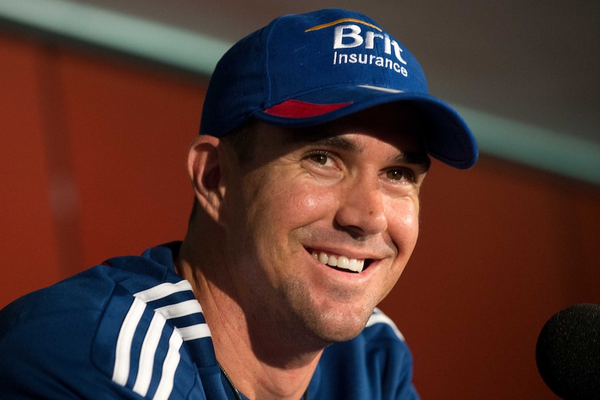 A man sits down with a blue cap on and a blue sports shirt