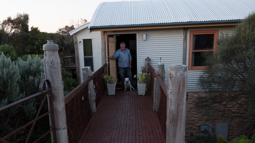 Brian OMalley and Dot the dog at the front door of their sustainable home.
