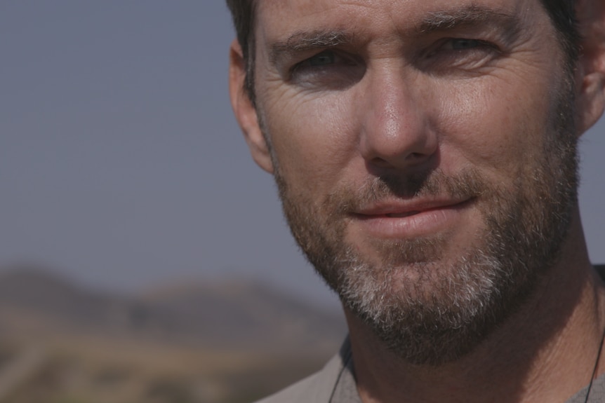 Headshot of Mike Bell, smiling at the camera, standing outside.