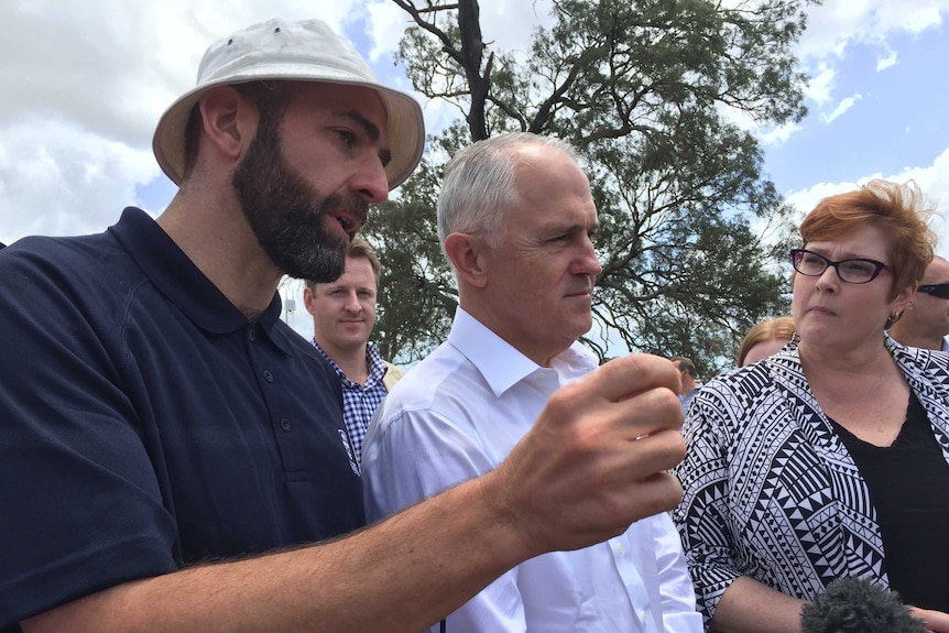 People stand with the Australian Prime minister and Defence minister under a large gum tree, Sydney