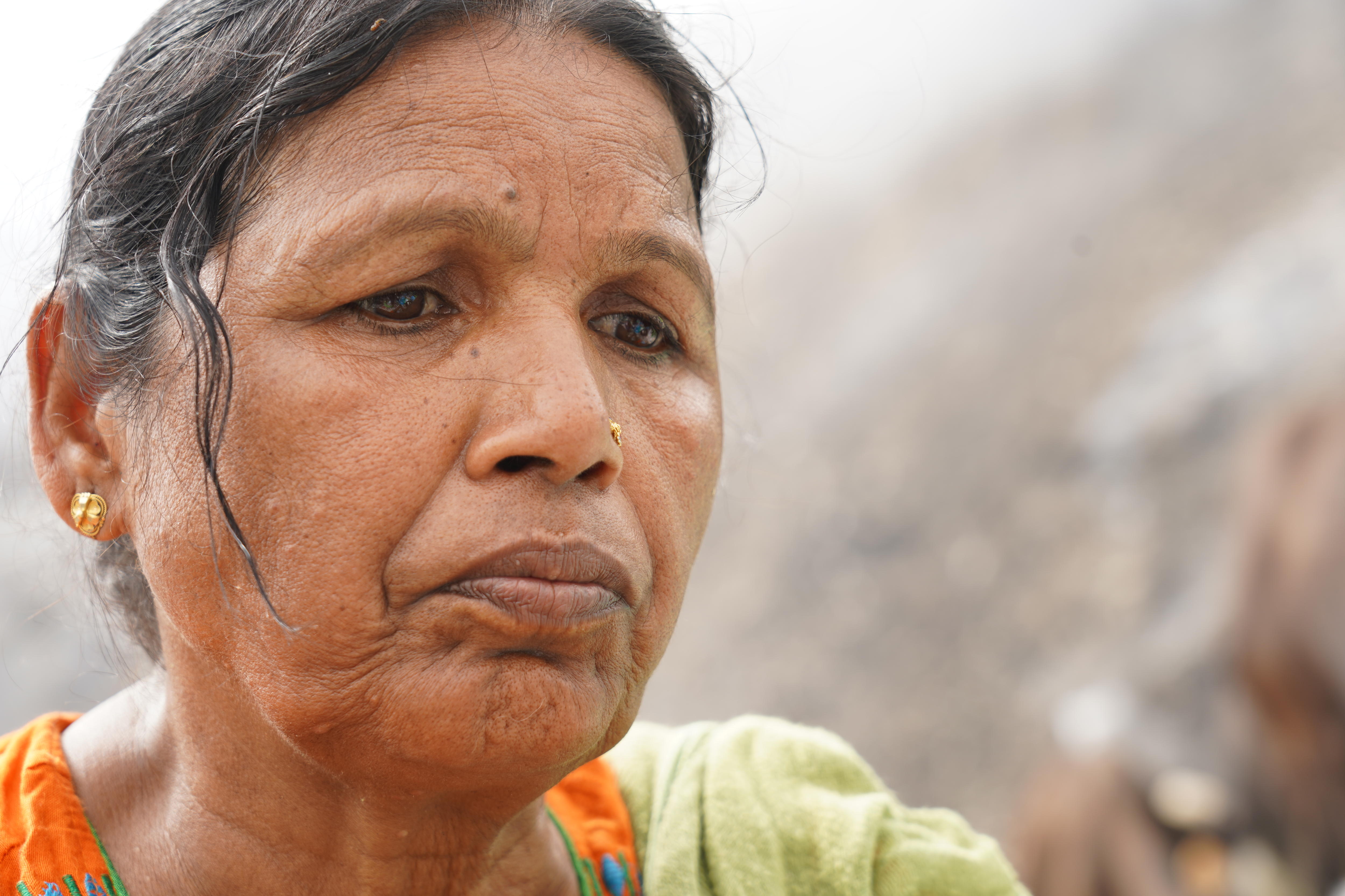 An Indian woman in an orange sari looking very hot and miserable 