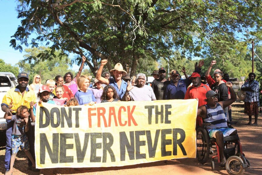 Indigenous activists against fracking, holding sign