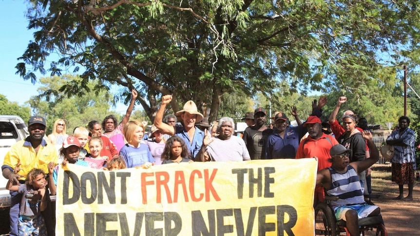 Indigenous activists against fracking, holding sign