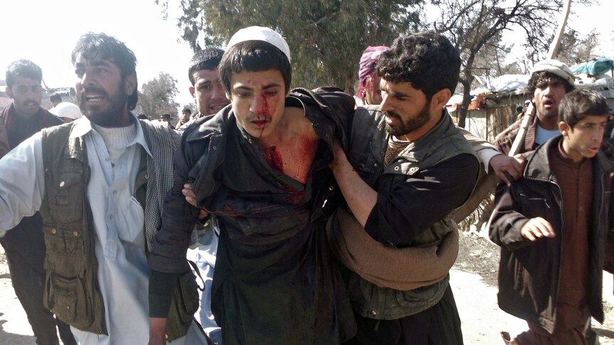Afghan demonstrators help a wounded man during a protest in Mihtarlam, east of Kabul.