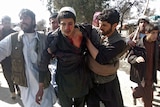 Afghan demonstrators help a wounded man during a protest in Mihtarlam, east of Kabul.