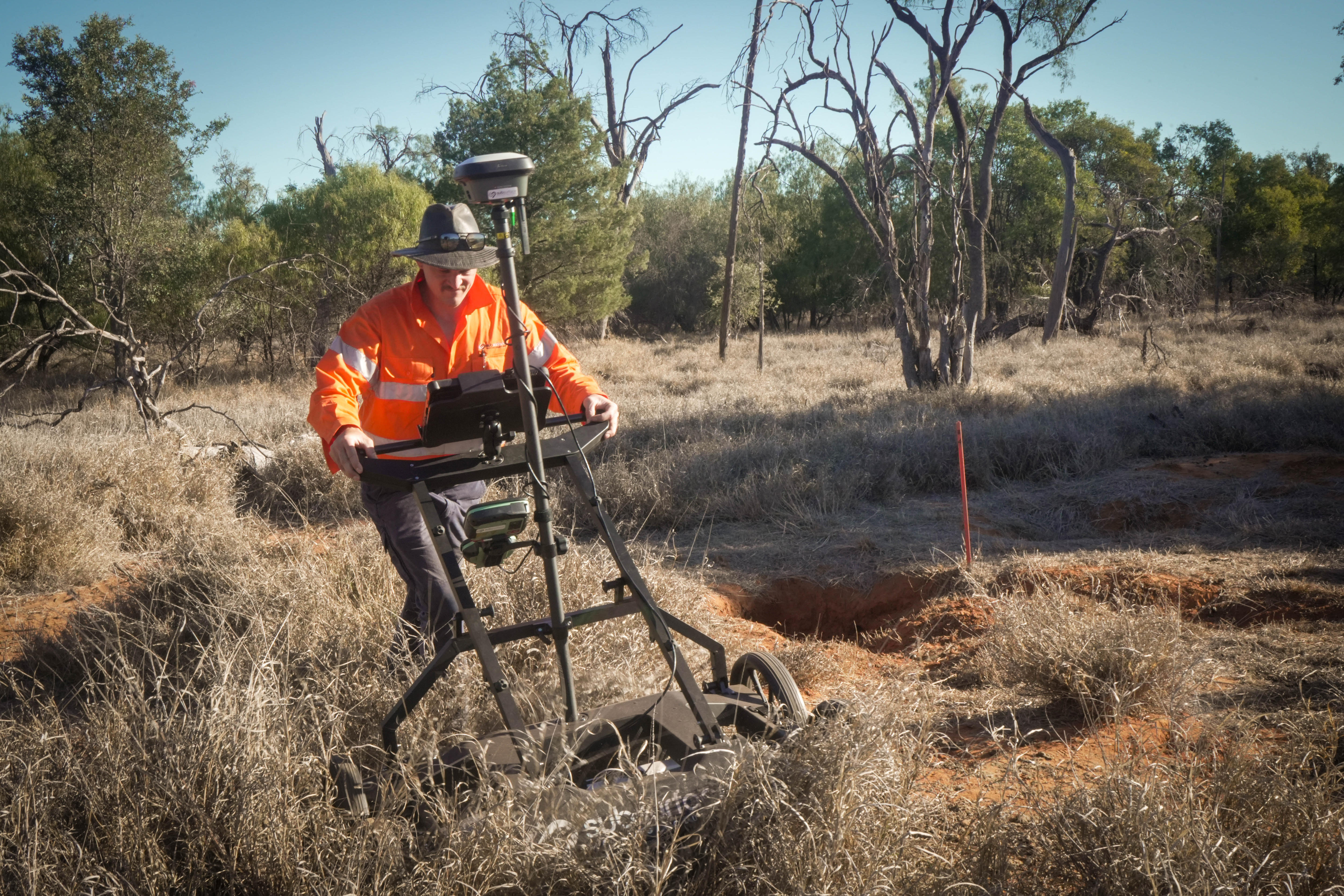 A man pushes a lawnmower-type device