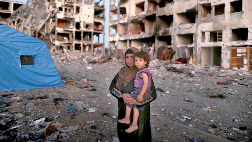 Palestinian woman returns to destroyed home in Gaza