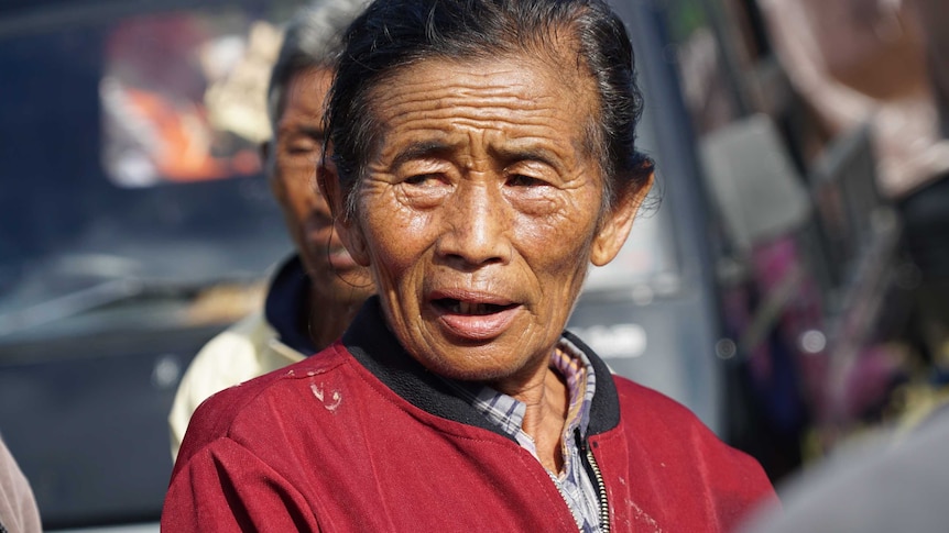 Nyoman Smah, 70, speaks outside an evacuation centre.