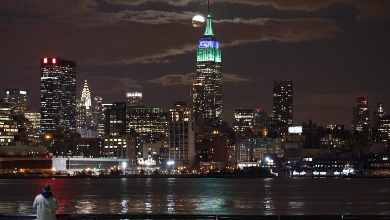 A full moon rises behind the Empire State Building in New York