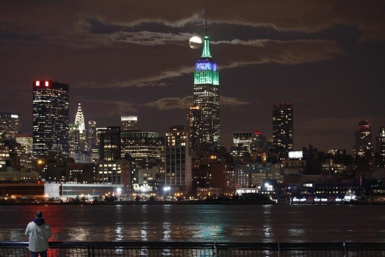 A full moon rises behind the Empire State Building in New York