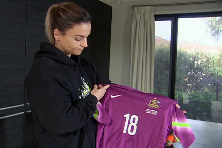 Melissa Barbieri looks at a football top.