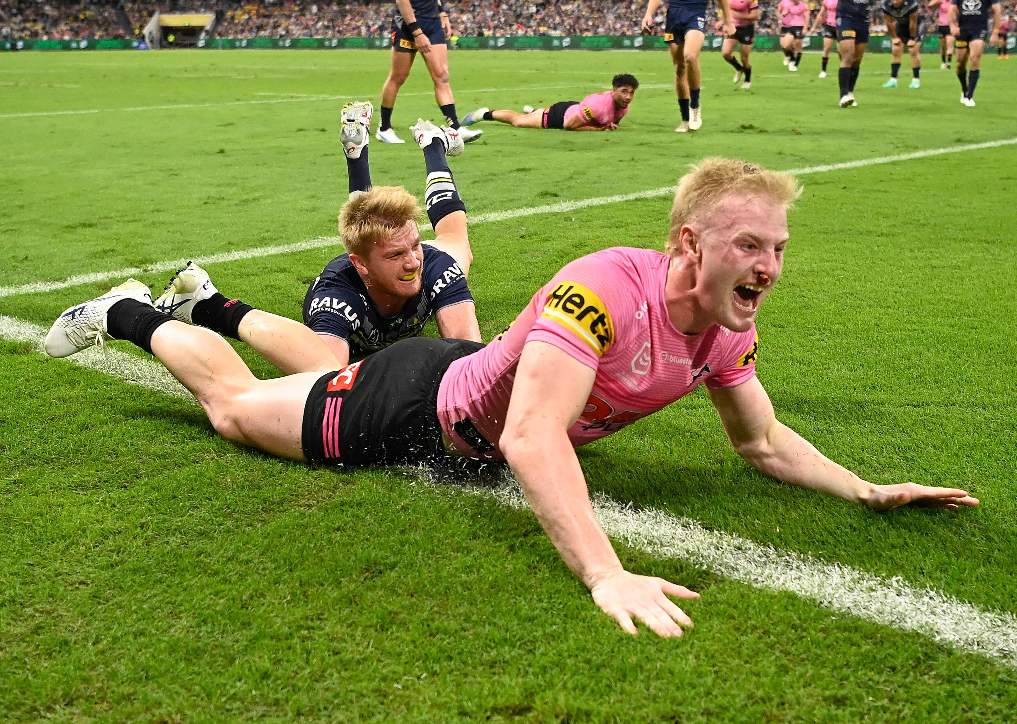 A man celebrates after scoring a try in a rugby league match 