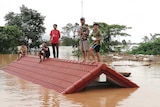 Villagers take refuge on a rooftop above the floodwaters.