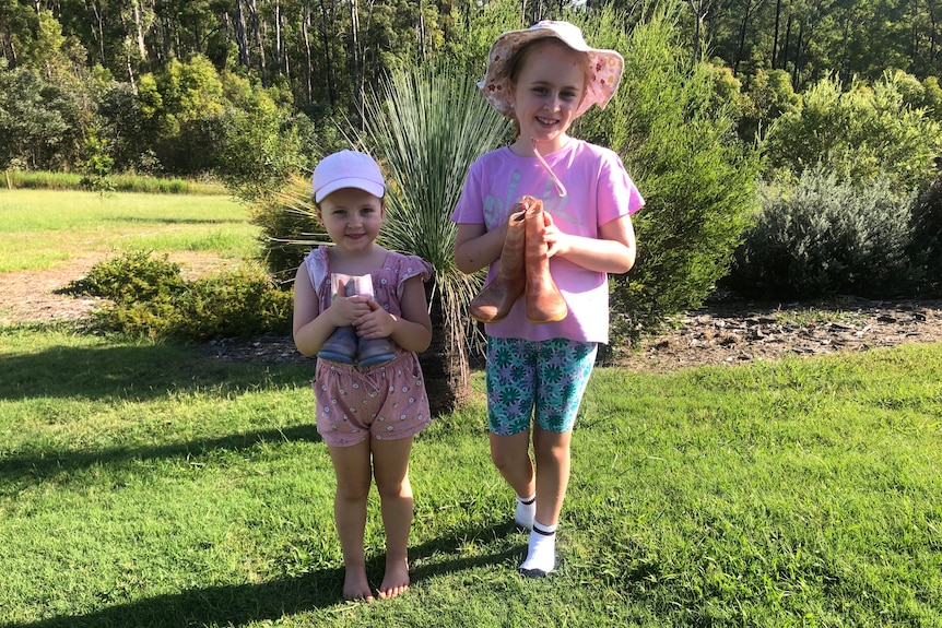 Grace and Eva Moore holding their gum boots.