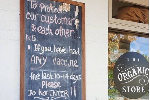 A sign outside an organic store discouraging vaccinated patrons from entering.