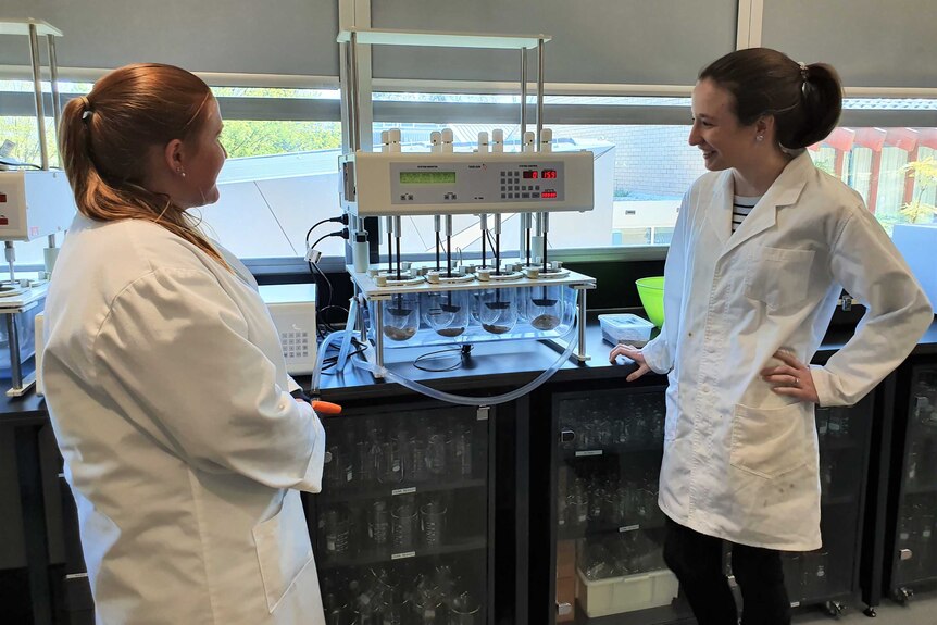 Two women in white coats in a laboratory.