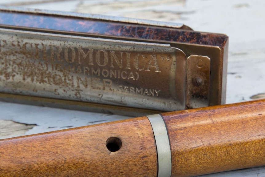 Close up of old wooden recorder and rusty harmonica.