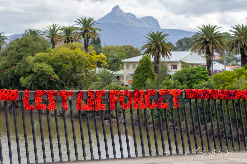 A bridge rail with "Lest We Forget" spelled out in red poppies.