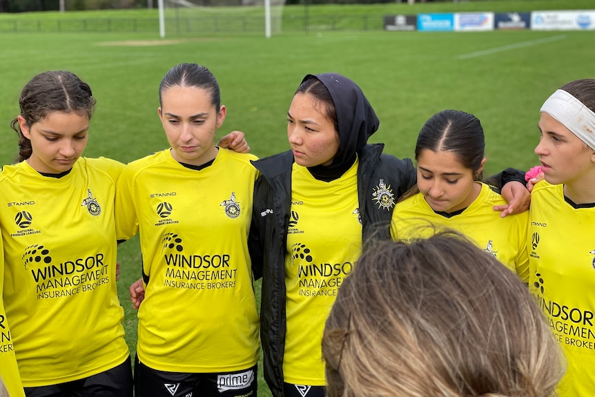 Setarah Qasimi stands in a huddle with her teammates