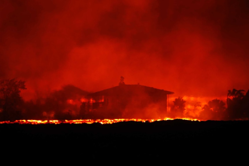 A house is seen in a distant red glow as Lava erupts around it