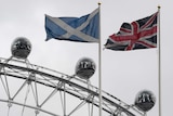 The British and Scottish Saltire flag fly above the Scottish Office in Whitehall, with the London Eye wheel seen behind.