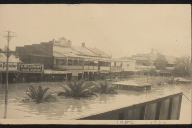 A sepia-toned photograph of a flooded streetscape in 1950